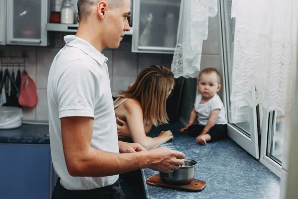 Loving family at kitchen. Dad cooking dinner while mom playing w — Stock Photo, Image