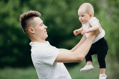 Genç baba bebek kız açık havada ile oynamak.