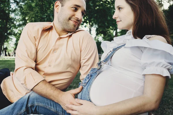 Мать и отец обнимают беременный живот — стоковое фото