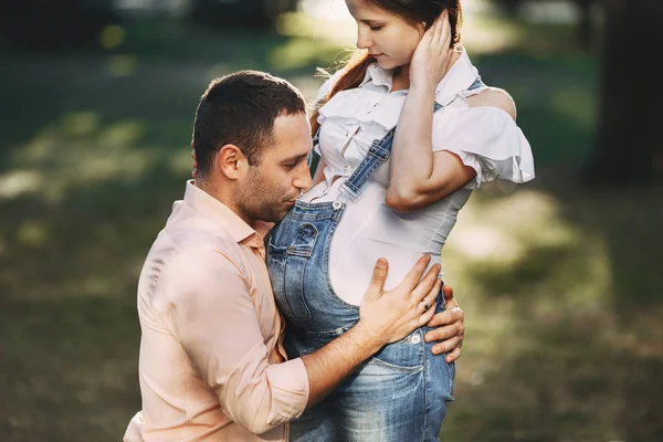 Hombre abrazando y besando embarazada esposas vientre — Foto de Stock