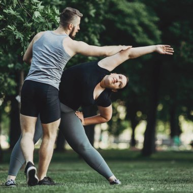 Kişisel antrenör kilolu kadın sokak egzersiz yardım