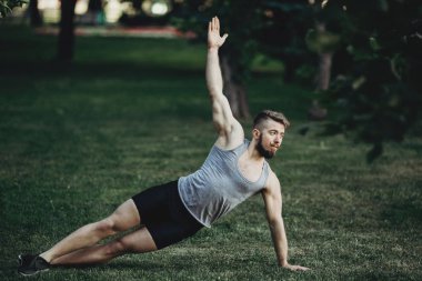 Yan tahta açık havada yapan kaslı erkek uygun