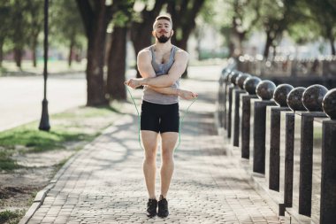 Uygun kaslı adam açık havada atlama ipi kullanarak atlama