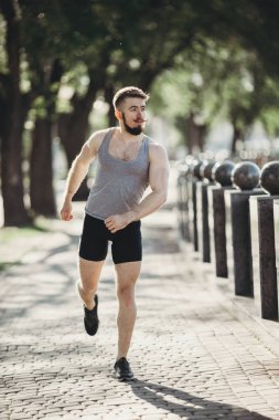 Kent parkta koşan kaslı adam genç yerleştirmek