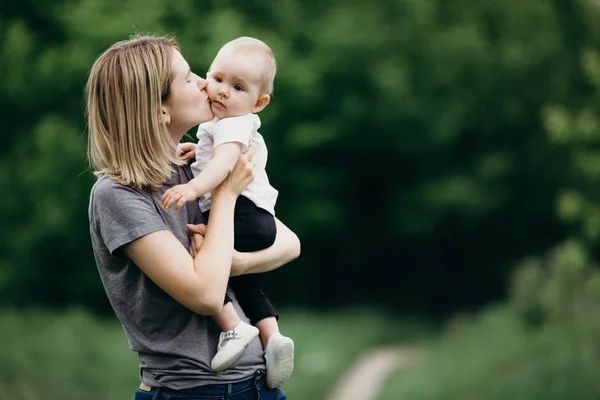 Madre cariñosa besando a su hija bebé al aire libre —  Fotos de Stock