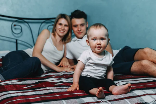 Familieportret - ouders en dochter op bed — Stockfoto