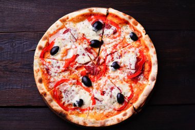 Pizza salam ve siyah zeytin ile ahşap üzerine dilimlenmiş
