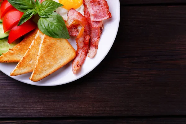 Huevos fritos con tocino, tostadas y verduras frescas —  Fotos de Stock