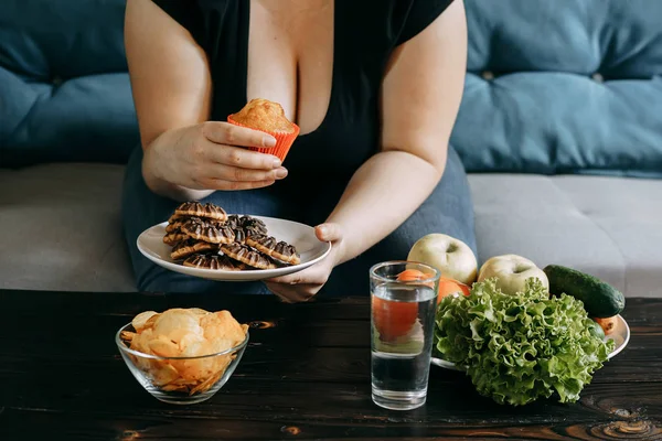 Overweight woman eating junk and sweet snacks — Stock Photo, Image