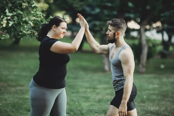 Plus tamaño mujer dar alta cinco a entrenador personal — Foto de Stock