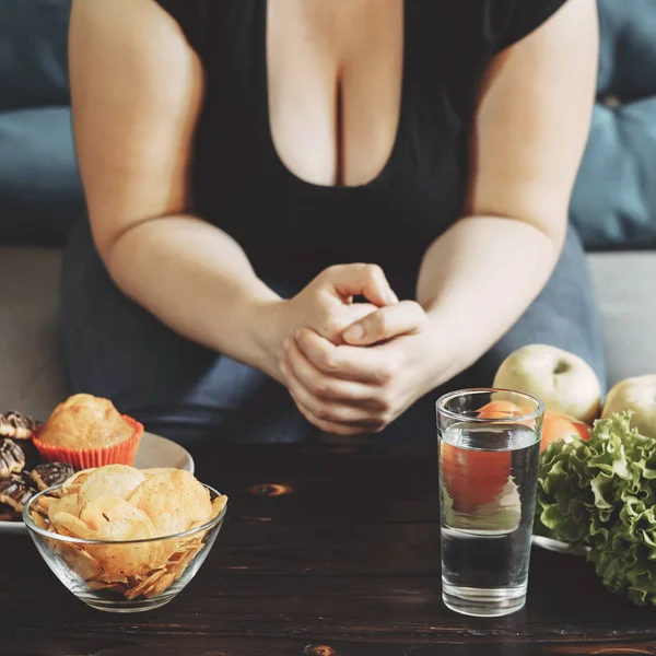 Mujer obesa elegir entre dulces y verduras — Foto de Stock