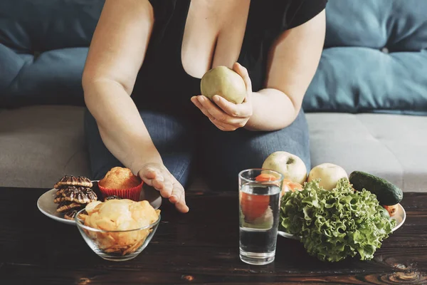 Mulher obesa escolhendo legumes recusando junk food — Fotografia de Stock