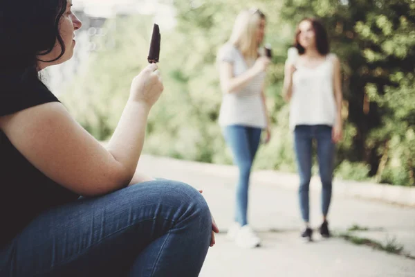 Mujer obesa comiendo envidia helado para adaptarse a las niñas —  Fotos de Stock