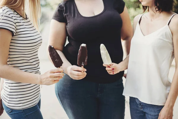 Sobrepeso e mulheres aptas a comer sorvete — Fotografia de Stock