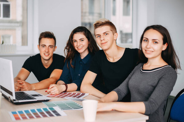 team of designers sitting together at studio