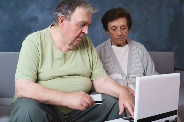 Пожилая пара с кредитной картой оплачивает счета онлайн — стоковое фото