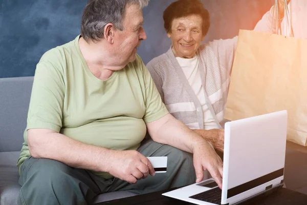 Пожилая пара с ноутбуком покупки в интернет-магазине — стоковое фото