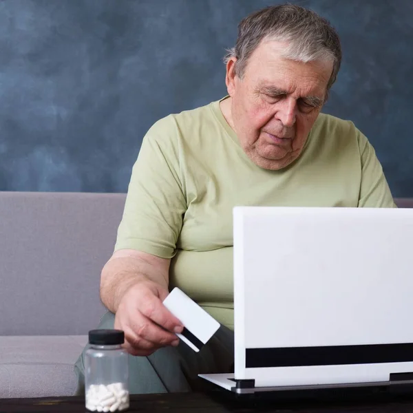 Старик проверяет рецепты лекарств онлайн — стоковое фото