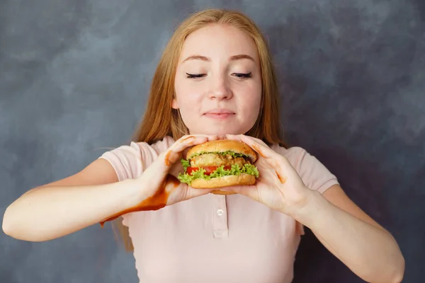 Linda mujer con hamburguesa en las manos disfrutar del aroma —  Fotos de Stock