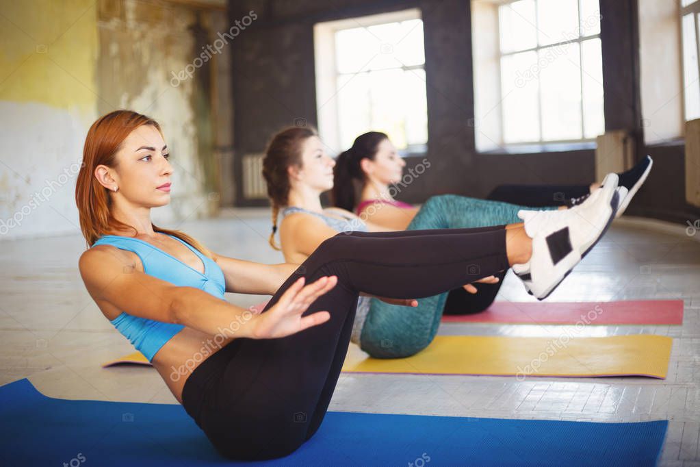 Sporty women doing abdominal crunches at workout