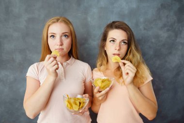 Patates cipsi yemek iki ilgisiz kadın