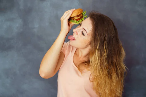 Mujer comiendo hamburguesa manchando las manos con salsa —  Fotos de Stock