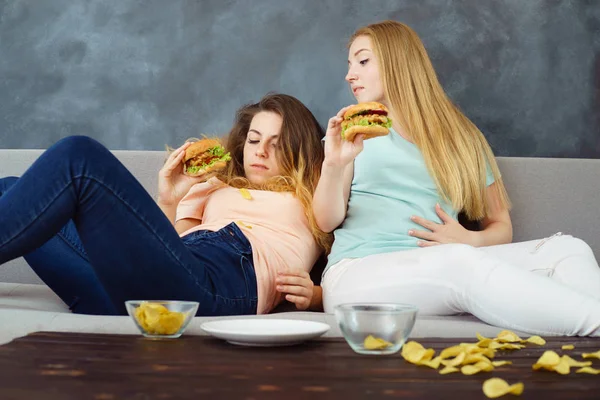 Donne mangiate troppo sdraiato a allenatore mangiare fast food — Foto Stock