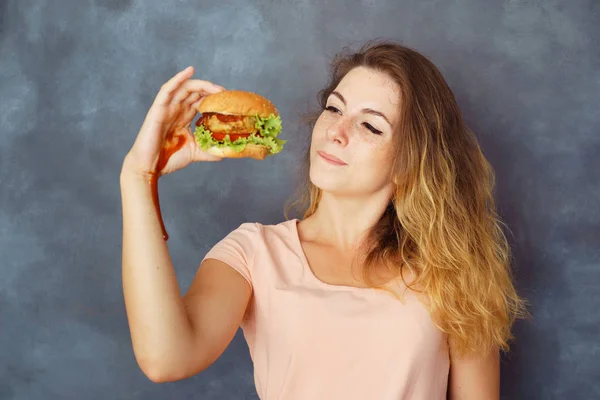 Mujer joven luchando contra la tentación de comer hamburguesa —  Fotos de Stock