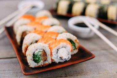 kil tabak, yemek çubukları ve sos suşi rulo