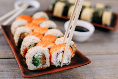 Suşi alarak chopsticks çifti rulo yakın kadar