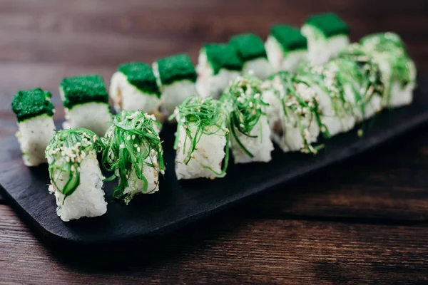 Японские суши-роллы на тарелке, выборочная фокусировка — стоковое фото