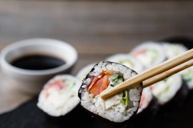 Suşi alarak yemek çubuğu çift--dan tepsi rulo, yakın çekim