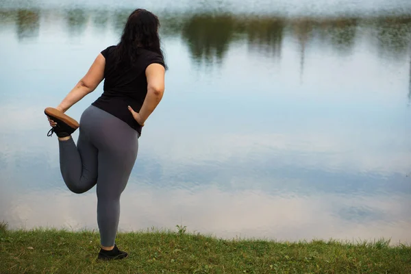Túlsúlyos nő, nyúlik a lábát futtatása előtt — Stock Fotó