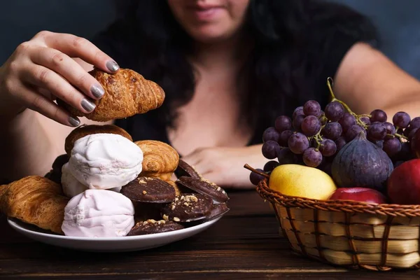 Mulher gorda escolhendo entre junk food e frutas — Fotografia de Stock