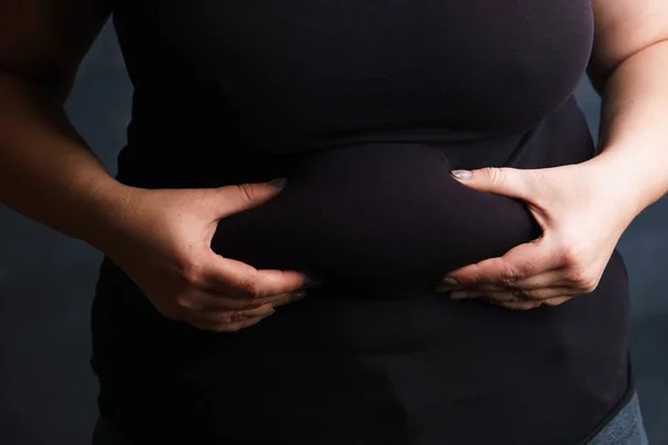 Donne in sovrappeso mani toccando il grasso della pancia — Foto Stock