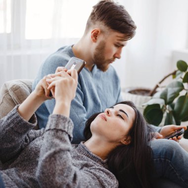 Akıllı telefonlar bir kanepede kullanarak çift