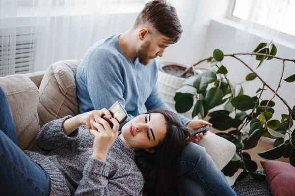 Paar im Wohnzimmer mit Smartphones — Stockfoto