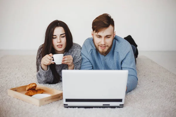 couple drinking coffee watching TV series at home