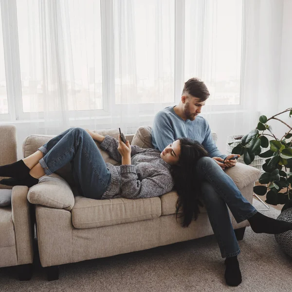 Casal na sala de estar obcecado com smartphones — Fotografia de Stock