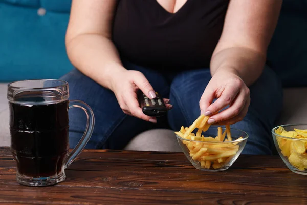 Mujer obesa con control remoto de televisión, comida chatarra y cerveza — Foto de Stock