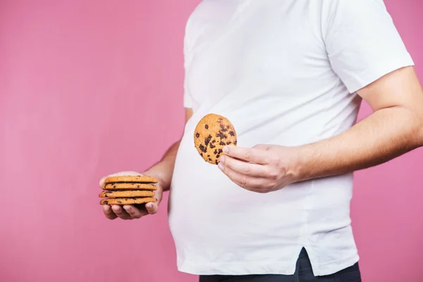 Adicción al azúcar, hombre obeso con un montón de galletas — Foto de Stock