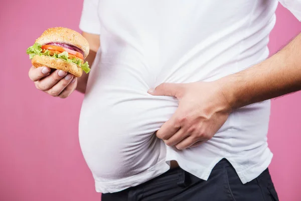 Alimentación poco saludable, hombre con barriga grande y hamburguesa — Foto de Stock