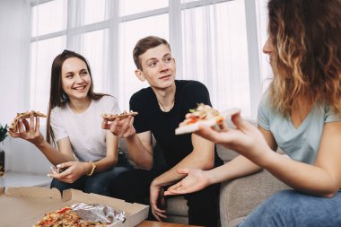 Pizza yemek ve evde parti konuşan arkadaşlar