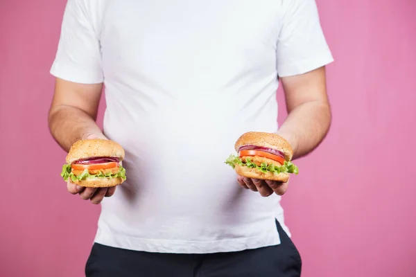 fat man with two burgers. hunger, unhealthy diet