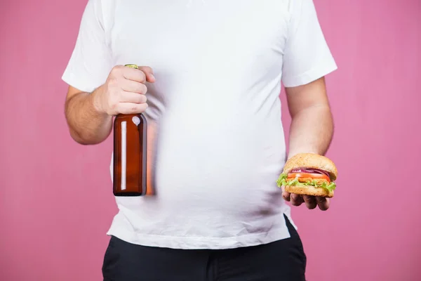 Нездорова їжа. жирний чоловік з пивом і бургер — стокове фото