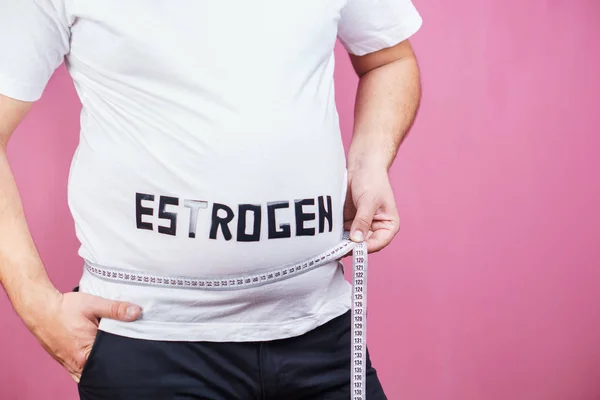 Рівень естрогену, надмірна вага людини з вимірювальною стрічкою — стокове фото