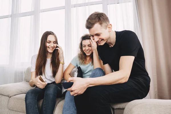 Jóvenes riendo viendo vídeo en smartphone —  Fotos de Stock