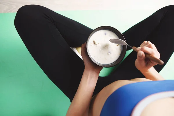 Прилежная женщина ест протеиновые закуски после тренировки — стоковое фото