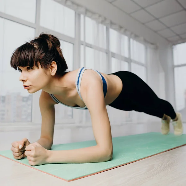 Entrenamiento de yoga en el estudio, mujer haciendo ejercicio de tablón — Foto de Stock