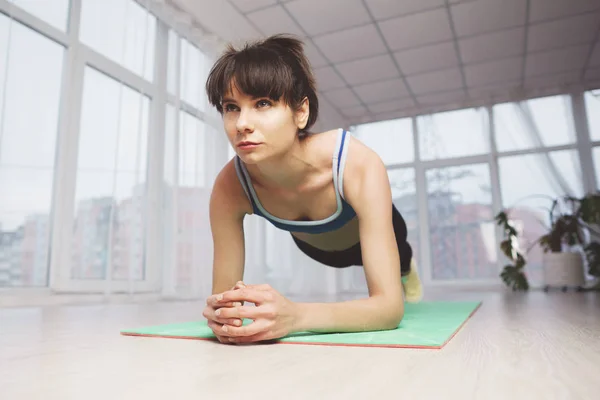 Entrenamiento en el estudio, mujer haciendo ejercicio de tablón — Foto de Stock